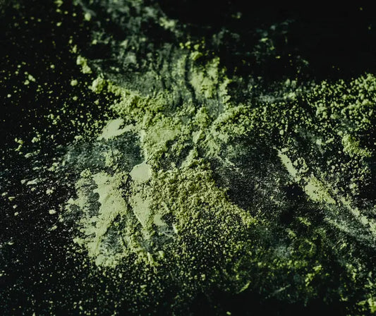 Broccoli sprout powder jar beside green smoothie ingredients on a kitchen bench in New Zealand