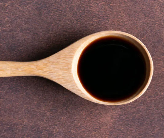 Blackcurrant juice, purple powder and capsule extract arranged on a natural kitchen bench