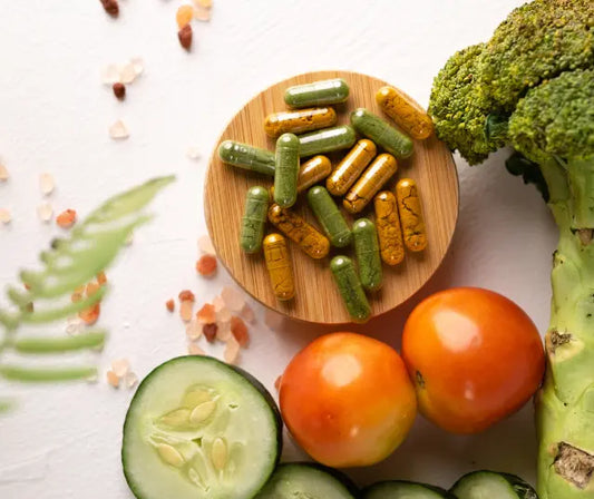Digestive enzyme supplement bottle showing its back label beside gold and green kiwifruit and capsules