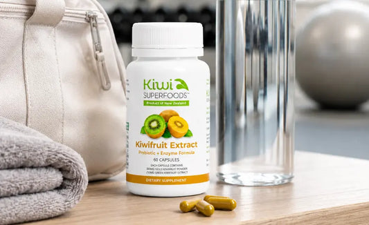 Two prebiotic fibre capsules beside fresh gold and green kiwifruit representing the Kiwi Superfoods NZ kiwifruit formulation.