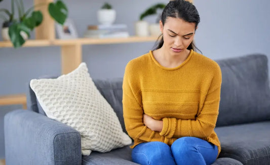 Person comfortable in the morning and feeling bloated at night beside green and gold kiwifruit